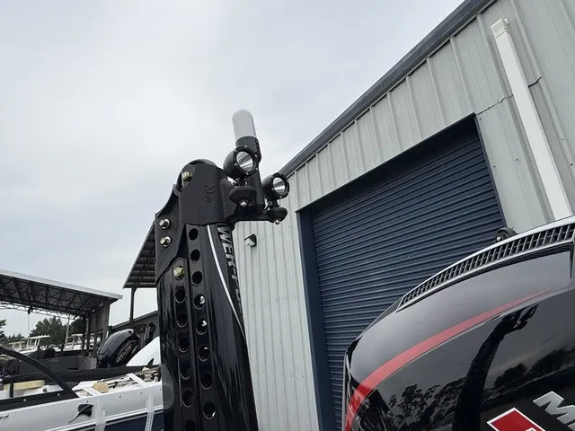 Slide: The Image of A 2027 Phoenix 921 Elite X II with a powerful outboard motor, parked beside a building. - 29