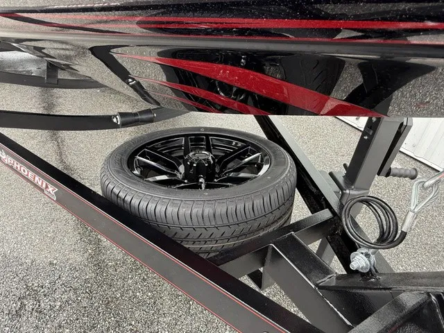 Slide: The Image of A black spare tire is mounted under a Phoenix 921 Elite X II boat trailer. - 14