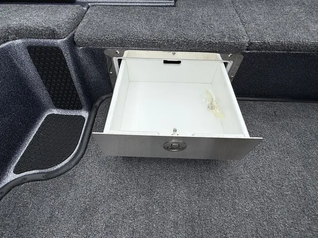 Slide: The Image of An open storage compartment with gray carpeting and a white interior. - 23