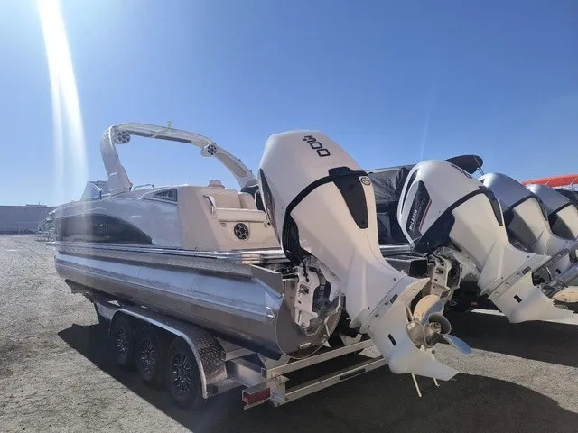 Slide: The Image of A modern pontoon boat with twin powerful outboard engines, on a trailer under clear skies. - 3
