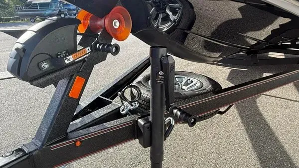 Slide: The Image of Close-up of a boat trailer with a spare tire and jack stand, on a parking lot. - 12