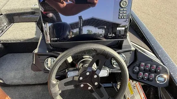 Slide: The Image of The image shows the cockpit of a 2026 Skeeter ZXE20 boat with modern steering and electronics. - 21