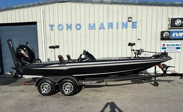 The Image of A black Skeeter ZXE20 boat from 2026 is on a trailer in front of a building labeled "TOHO MARINE." - 1