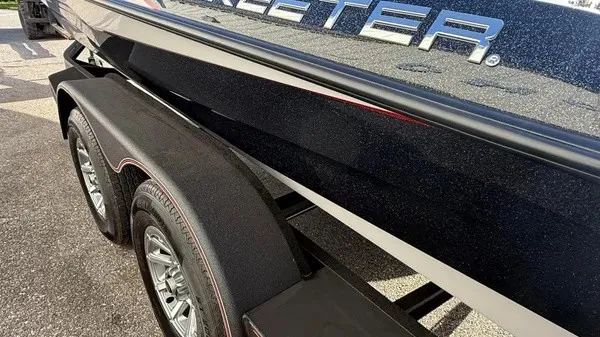 Slide: The Image of Close-up of a Skeeter boat on a trailer, showcasing its glossy black finish. - 8