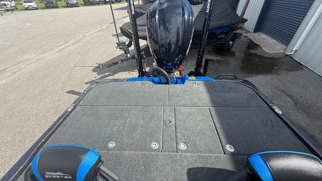Slide: The Image of The image shows the deck of a 2027 Skeeter ZXE21 boat with gray carpeting. - 12