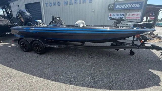 The Image of A 2027 Skeeter ZXE21 on a trailer in front of a building with boat brand logos. - 1