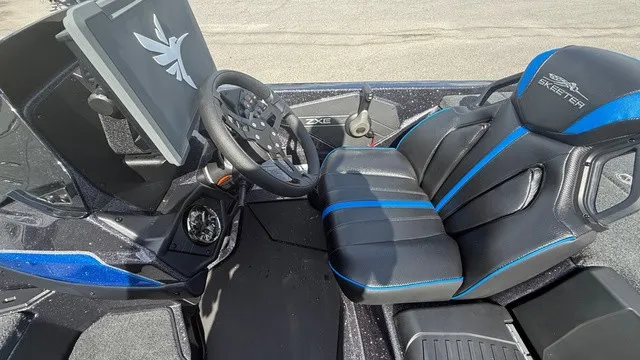 Slide: The Image of The image shows the cockpit of a 2027 Skeeter ZXE21 boat with a modern steering wheel and padded seat. - 9