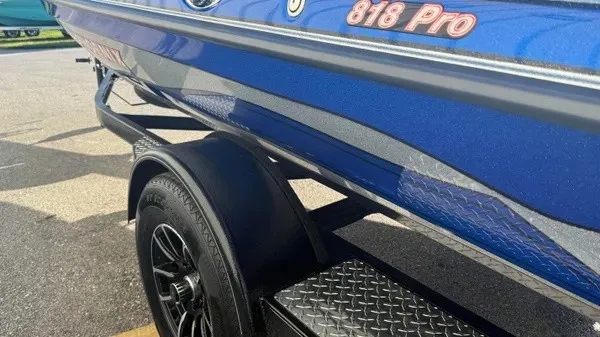 Slide: The Image of A blue 2027 Phoenix 818 Pro on a trailer, featuring black wheels and silver accents. - 7