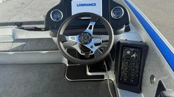 Slide: The Image of The image shows the cockpit of a Phoenix 818 Pro boat with a steering wheel and instruments. - 16