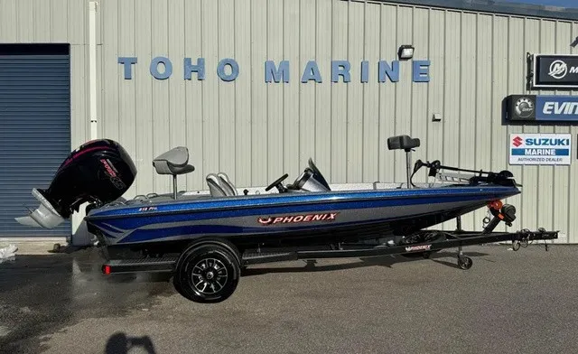 The Image of A blue Phoenix 818 Pro boat on a trailer in front of a building with a "Toho Marine" sign. - 1
