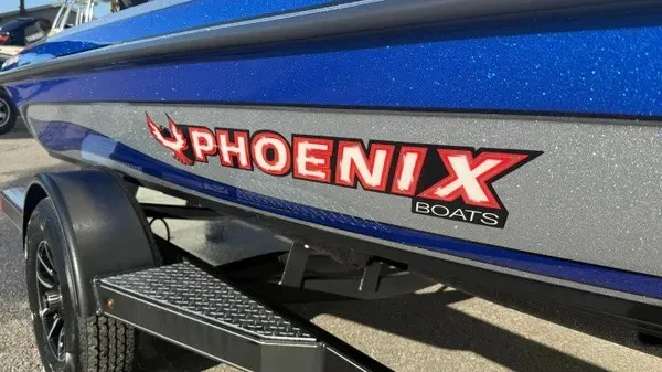 Slide: The Image of Close-up of a blue Phoenix 818 Pro boat from 2027 on a trailer. - 2