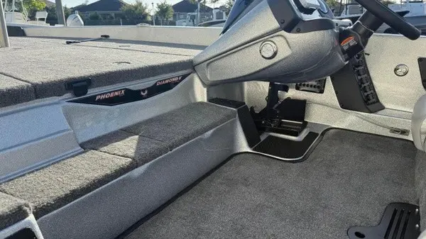 Slide: The Image of The image shows the cockpit of a Phoenix 818 Pro boat with gray carpeting and a steering console. - 19