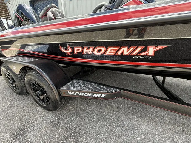 Slide: The Image of A 2027 Phoenix 920 Elite X II boat with black and red design on a trailer. - 2