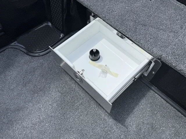 Slide: The Image of An open drawer in a boat with gray carpeted flooring. - 17