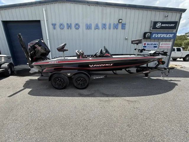 The Image of A 2027 Phoenix 920 Elite X II is parked in front of a building with various boat brand signs. - 1