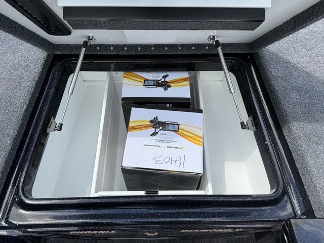 Slide: The Image of An open storage compartment on a Phoenix 920 Elite X II boat with two boxes inside. - 18
