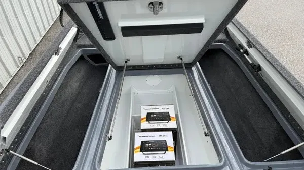 Slide: The Image of The image shows the storage compartment of a Phoenix 920 Elite X boat with two boxes inside. - 12