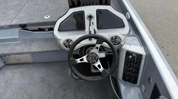 Slide: The Image of The image shows the cockpit of a 2027 Phoenix 920 Elite X boat with a modern steering wheel and instruments. - 19