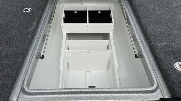 Slide: The Image of An open storage compartment on a boat with gray carpeting and white dividers. - 15