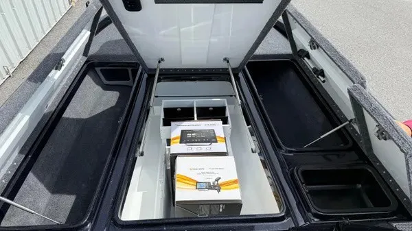 Slide: The Image of The image shows the storage area of a 2027 Phoenix 921 Elite X boat with open hatches. - 13