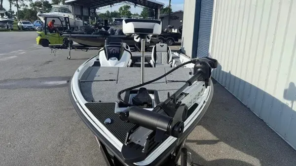 Slide: The Image of A modern fishing boat with a gray deck and black motor, parked in a marina area. - 10