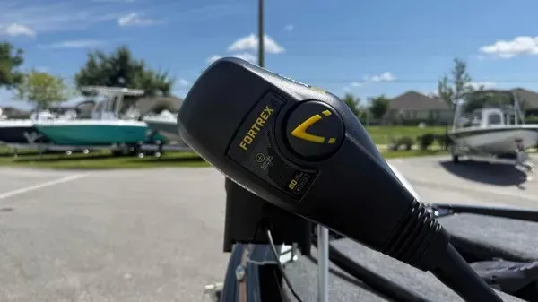 Slide: The Image of Close-up of a boat motor labeled "Fortrex." Boats and trees are visible in the background. - 11