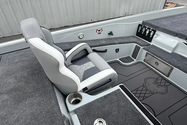Slide: The Image of The image shows the interior of a 2027 Phoenix 921 Elite X II boat. There's a cushioned seat and gray carpeting. - 17