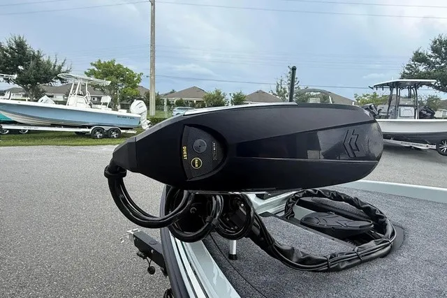 Slide: The Image of A modern boat with a black motor on a trailer, surrounded by other boats and trees. - 8