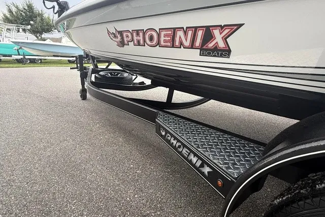 Slide: The Image of A Phoenix 921 Elite X II boat on a trailer, featuring a distinctive logo and sleek design. - 7