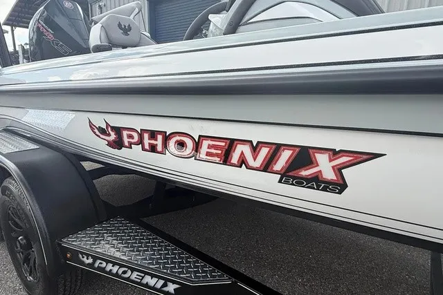 Slide: The Image of A 2027 Phoenix 921 Elite X II boat with a distinctive logo and sleek design. - 2