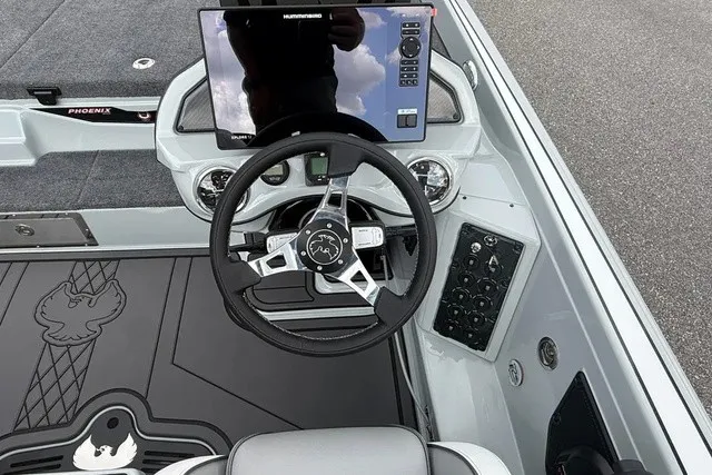 Slide: The Image of The image shows the cockpit of a 2027 Phoenix 921 Elite X II boat with a modern steering wheel and large display. - 16