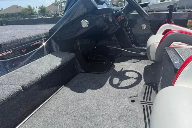 Slide: The Image of The image shows the cockpit of a 2027 Phoenix 819 ZXL boat with gray carpeting and a steering console. - 9