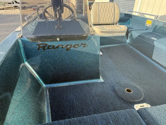 Slide: The Image of A 1985 Ranger 330-v boat with blue carpeting and a cushioned seat in the cockpit area. - 8