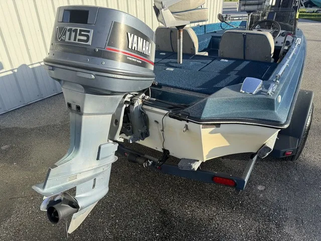 Slide: The Image of A 1985 Ranger 330-v boat with a Yamaha V115 outboard motor, parked on a trailer. - 3