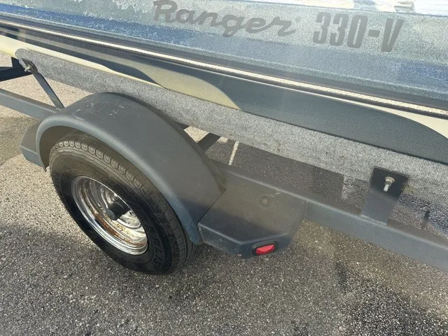 Slide: The Image of Close-up of a boat trailer with a Ranger 330-V boat on it. The trailer has a black fender. - 4