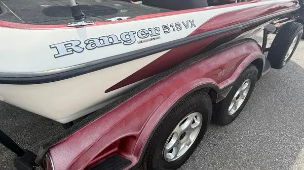 Slide: The Image of A 2007 Ranger 519 VX boat with a red trailer on asphalt. - 3