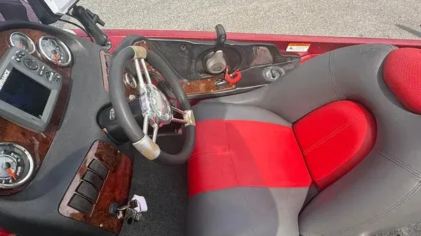 Slide: The Image of The image shows the driver's seat of a 2007 Ranger 519 VX boat with a red and gray seat and steering wheel. - 13