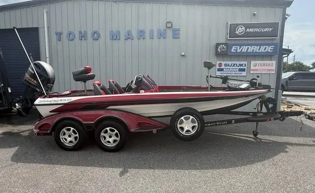 The Image of A 2007 Ranger 519 VX boat on a trailer in front of a building with various brand logos. - 1