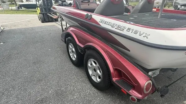 Slide: The Image of A 2007 Ranger 519 VX boat on a trailer, featuring a red and white design, parked on a lot. - 6