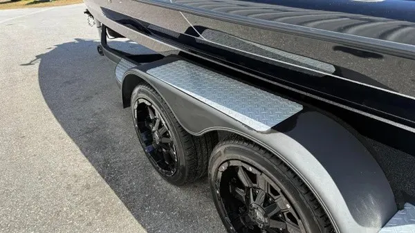 Slide: The Image of Close-up of a boat trailer with black wheels and silver step plates. - 4