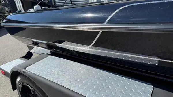 Slide: The Image of Close-up of a shiny black boat hull on a trailer with diamond plate. - 7