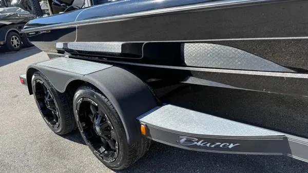 Slide: The Image of A black boat with shiny rims and a Blazer logo on the trailer. - 8