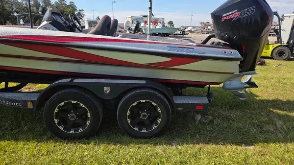 Slide: The Image of A 2021 Triton 20 TrX boat on a trailer, featuring a powerful outboard motor. - 6