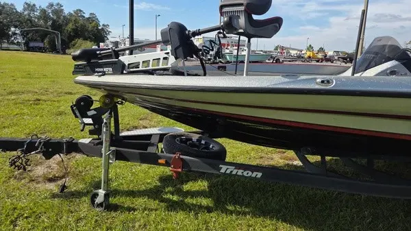 Slide: The Image of A 2021 Triton 20 TrX boat on a trailer, parked on grass. - 5