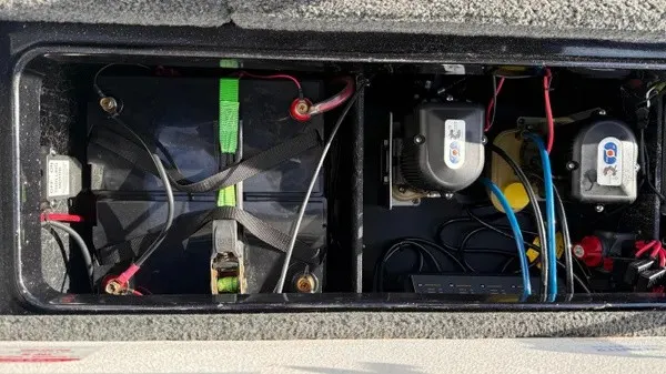 Slide: The Image of An open battery compartment with two batteries and wiring in a Ranger Z118 Comanche boat. - 20