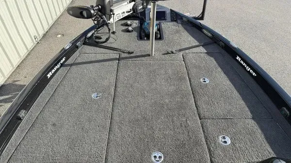 Slide: The Image of The image shows the deck of a 2015 Ranger Z118 Comanche boat with gray carpeting. - 12