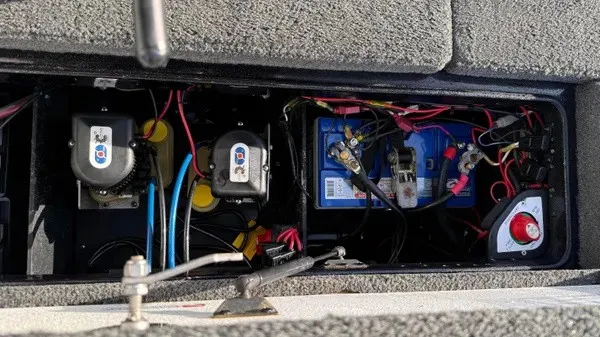 Slide: The Image of An open battery compartment with multiple batteries and wires in a Ranger Z118 Comanche boat. - 19