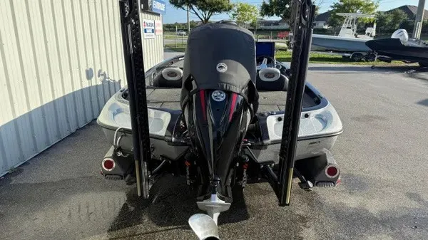 Slide: The Image of A 2015 Ranger Z118 Comanche boat with an outboard motor, parked in a lot. - 6