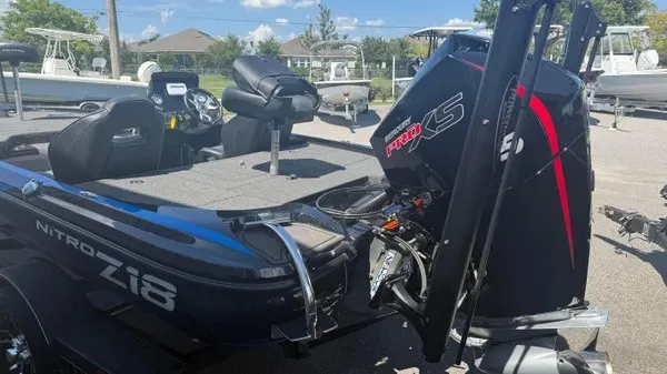 Slide: The Image of A black 2022 Nitro Z18 boat with a powerful outboard motor, parked in a yard. - 5