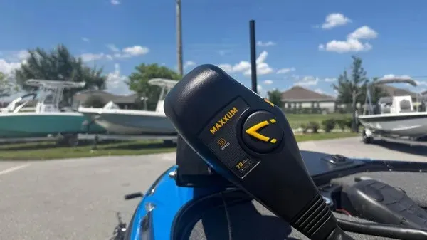 Slide: The Image of Close-up of a control lever on a blue boat, with other boats in the background. - 8